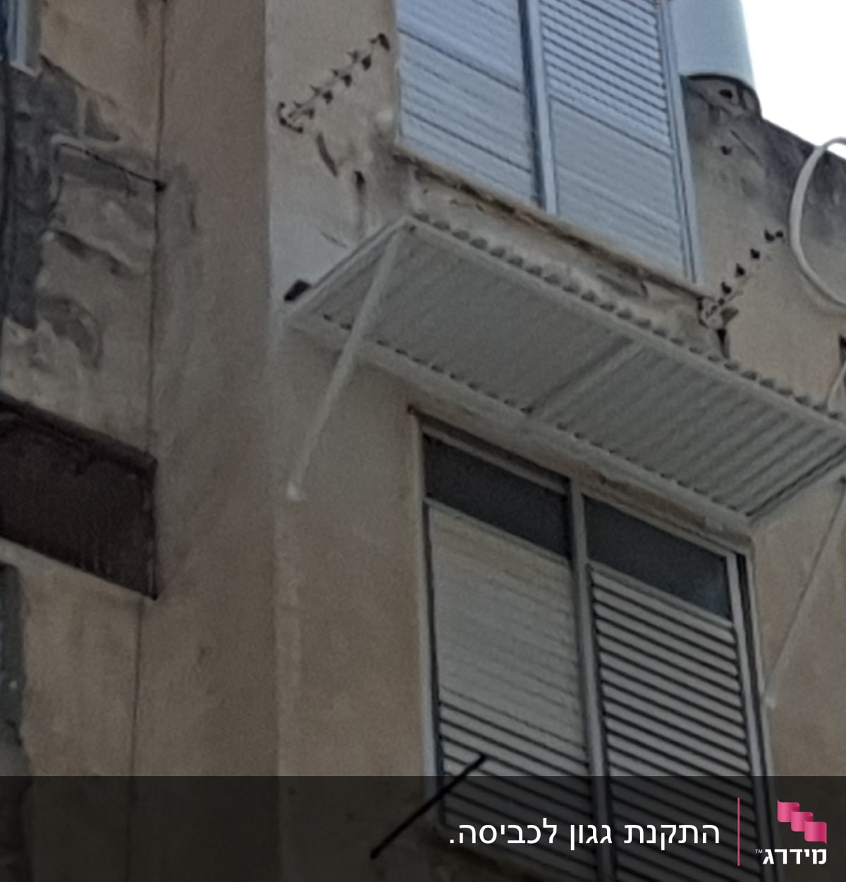 מרפסת אלומיניום עם תריסים סגורים על קיר בניין